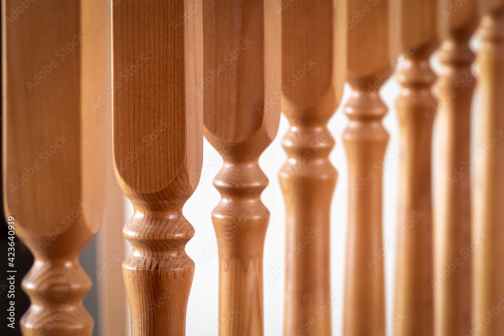 Element of a wooden interior staircase. Wooden baluster close-up. Element of a wooden interior staircase. Wooden baluster close-up.