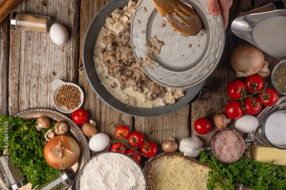 Chef prepares frying mushrooms with meat, top view on the background of ingredients, culinary recipes Chef prepares frying mushrooms with meat, top view on the background of ingredients, culinary recipes