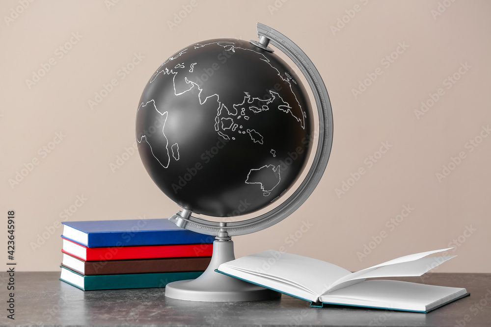 Globe with books on table against color background Stock Photo | Adobe ...