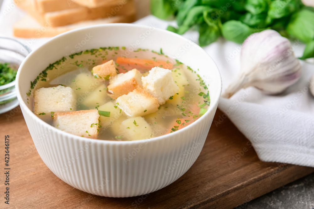 Bowl with tasty garlic soup on table, closeup