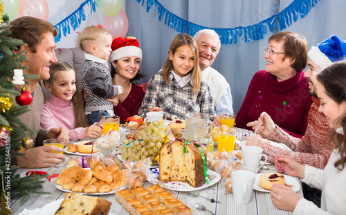 Large happy russian family talking animatedly during Christmas dinner.