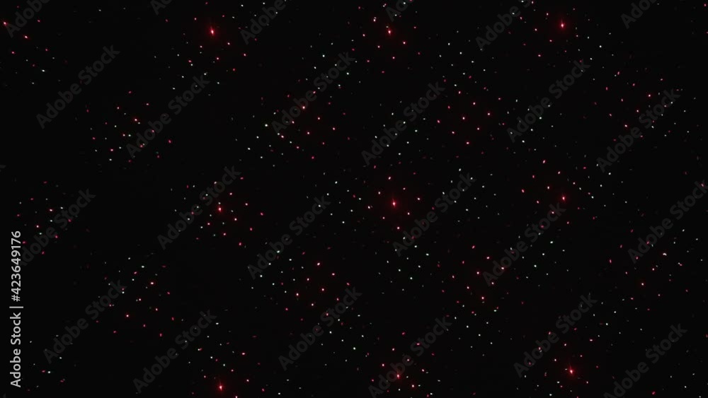 Slow motion. Flashing and rotating green and red laser beams create beautiful shapes against a dark background. Abstract dance of lines and light.