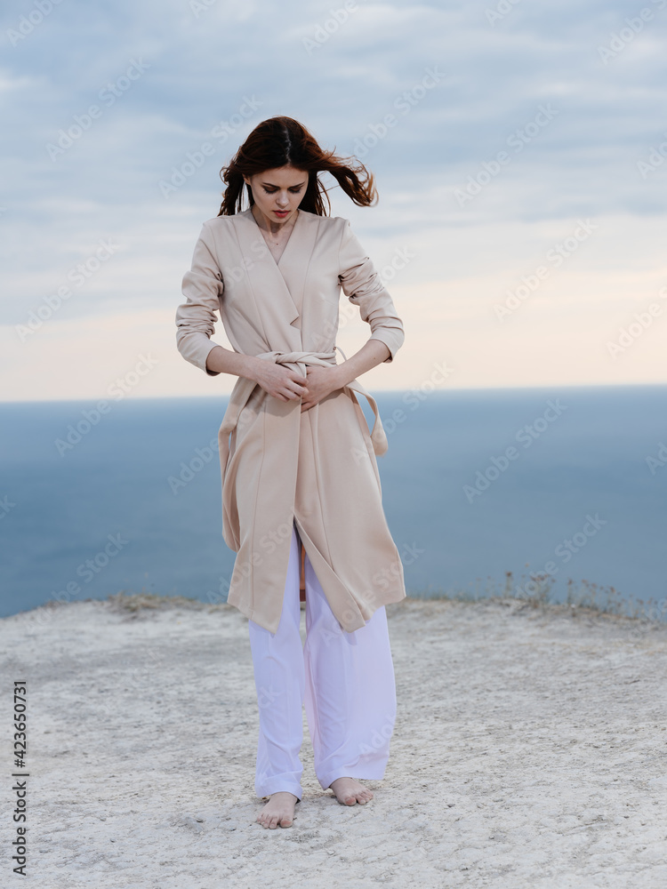 Traveler in light clothes in the mountains in nature and the ocean in the background Traveler in light clothes in the mountains in nature and the ocean in the background