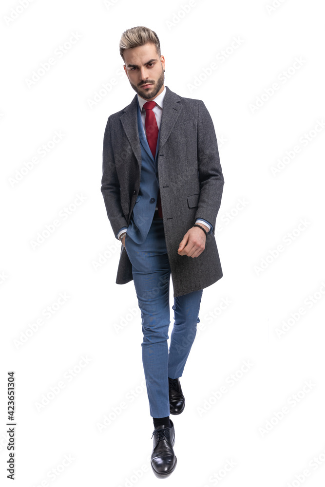 attractive young businessman in long coat holding hand in pocket attractive young businessman in long coat holding hand in pocket
