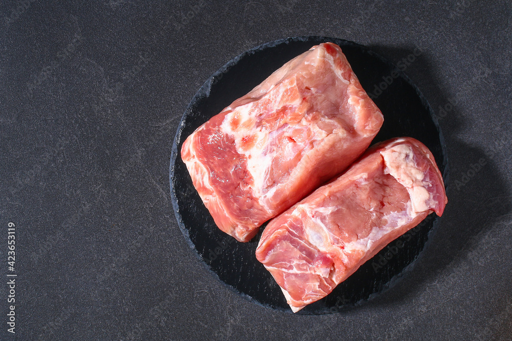 Raw pork loin. Pork meat on a gray background. Top view. Copy space.
