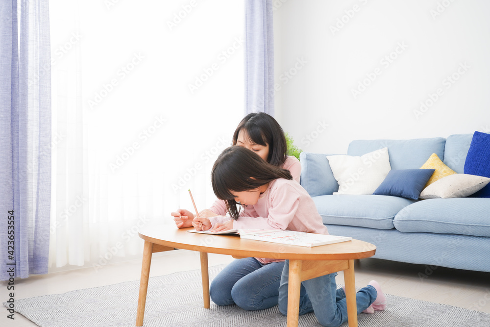 お家でお勉強をする女の子とお母さん