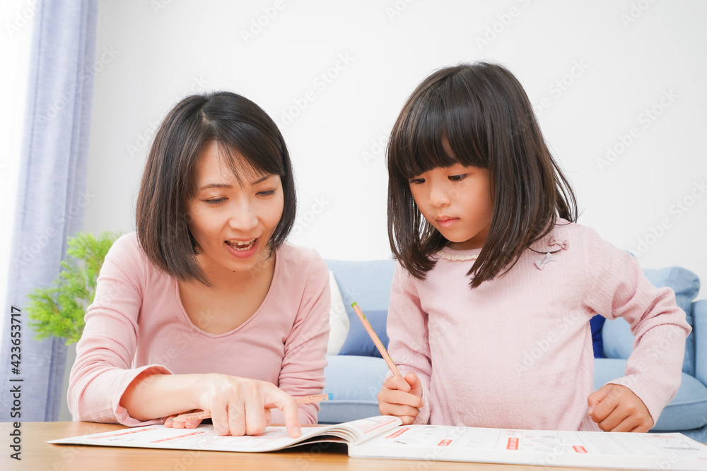 お家でお勉強をする女の子とお母さん お家でお勉強をする女の子とお母さん