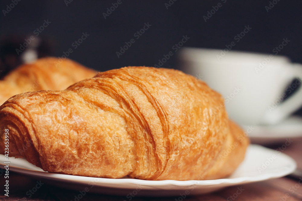 croissants in a plate a cup with a drink a meal dessert 