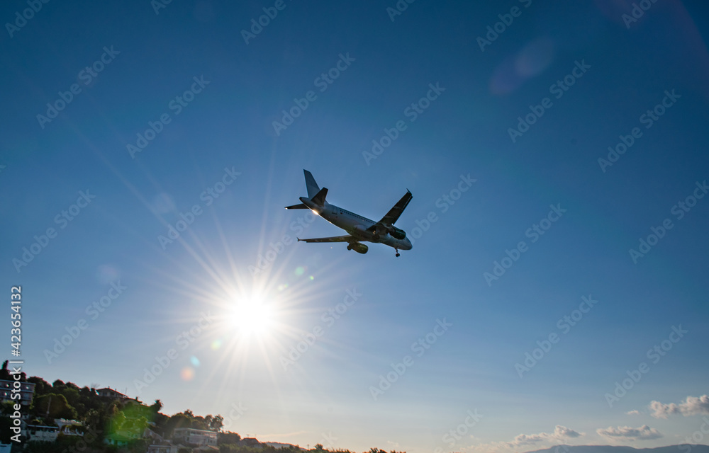A plane in the sky on a sunny summer day on the coast of Corfu. The Ionian Archipelago. Greece