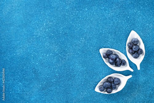 Blueberries, bog whortleberry, great biberry on a blue background. Top view. photo