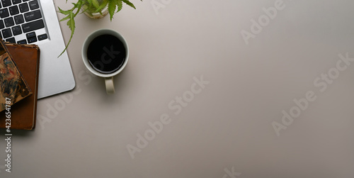 Horizontal photo of white office desk with laptop computer, coffee cup, notebook and copy space.