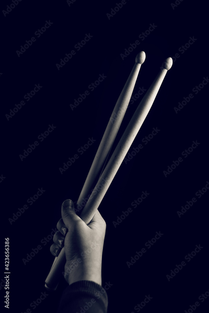 Child Hand Hold Wooden DrumSticks. Showing Devil Horns Sign, Symbol Of Heavy Metal On Black Backlit Red Background. Rock Music Concept. Sepia Toned Monochrome Photo Of Unrecognizable. Soft Focus Child Hand Hold Wooden DrumSticks. Showing Devil Horns Sign, Symbol Of Heavy Metal On Black Backlit Red Background. Rock Music Concept. Sepia Toned Monochrome Photo Of Unrecognizable. Soft Focus