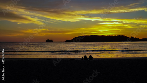 Beautiful view of a magical sunset in Carrillo beach with the silhouette of people enjoying life © Gian