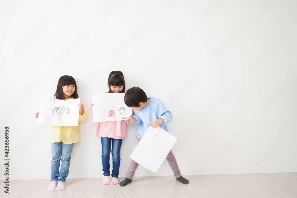 自分で描いた絵を見せる小さな子どもたち