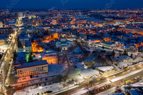 Beautiful evening top view of the city. Evening, night illumination in the city. Winter city in the snow. © zlatoust198323