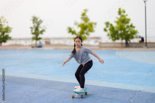 Asian girl playing surfskate in the park. sport and recreation concept