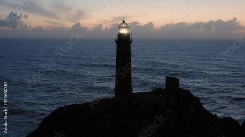 Lit lighthouse at dusk in Cape Vilan Galicia Spain Aerial view photo