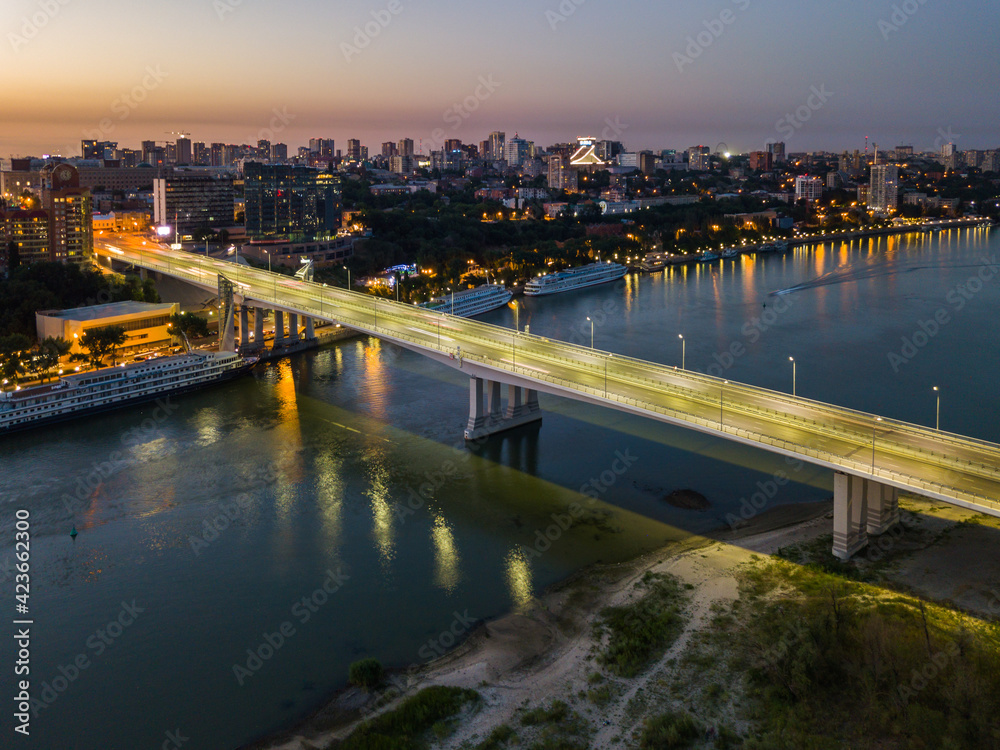 Rostov-on-Don, Russia - July 06, 2020: Voroshilovsky bridge at sunset and view of the left bank of the Don river, Rostov-Arena stadium with text Russia