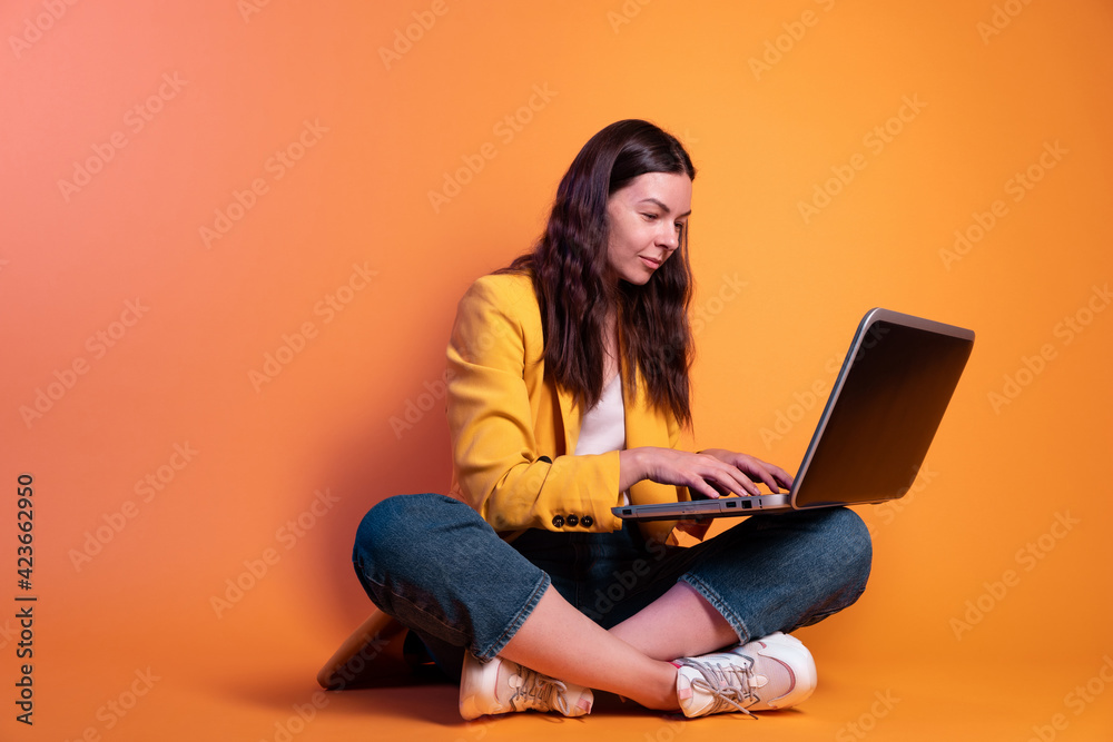 freelancer at a laptop, a young specialist working remotely. A young woman in modern-style clothing freelancer at a laptop, a young specialist working remotely. A young woman in modern-style clothing