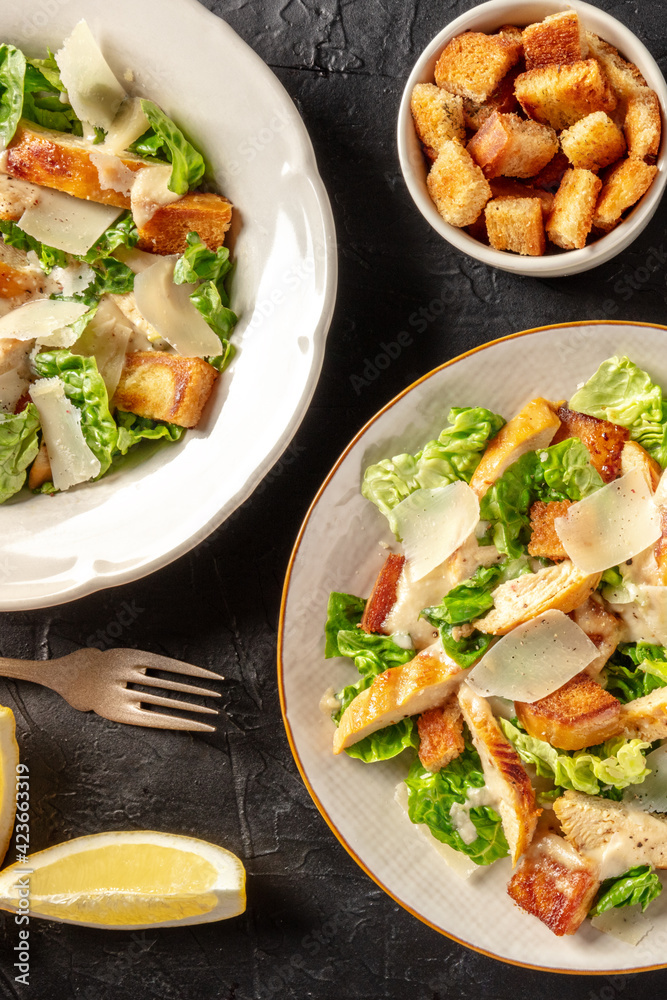 Chicken Caesar salad, shot from the top with croutons and lemons Chicken Caesar salad, shot from the top with croutons and lemons