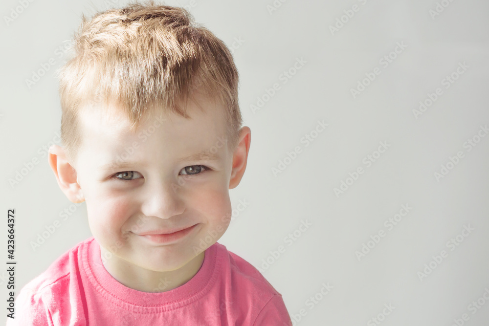 A smiling boy in a pink T-shirt. Portrait of a happy child. A smiling boy in a pink T-shirt. Portrait of a happy child.