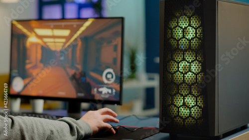 Fotografie Close up of RGB powerful computer gamer rig with first-person shooter game on screen, pro cyber man participating at online esports championship