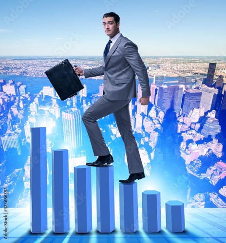 Businessman climbing bar charts in business concept © Elnur