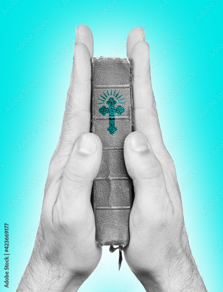 Fototapeta premium Praying hands holding the old bible