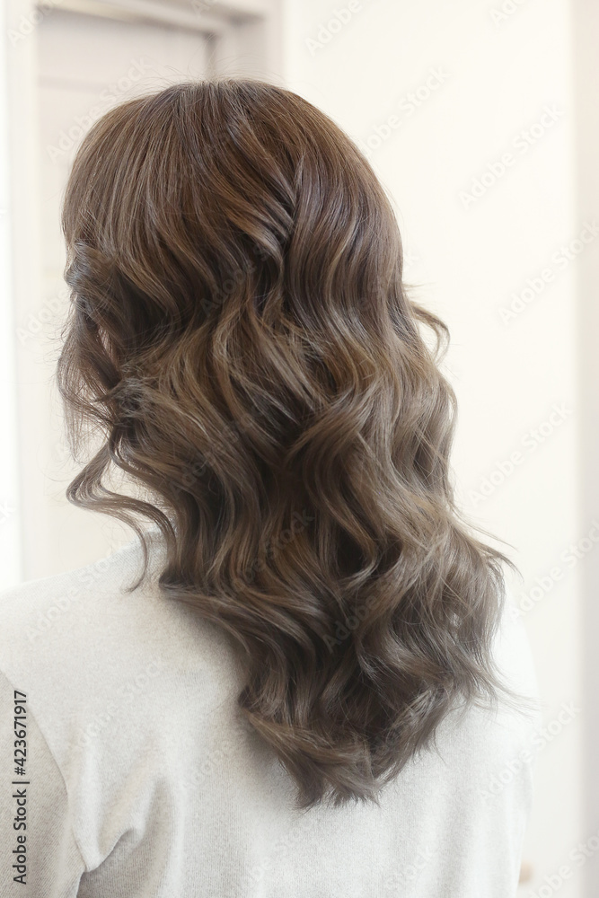 Naklejka premium light brown long curly loose hair closeup photo in hair salon back view