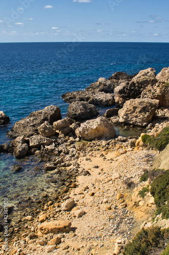 Rocks and blue water on a warm fall day in Prajjet Bay or Anchor Bay, Malta. photo