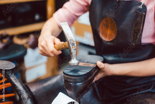Close-up of woman shoemaker repairing some shoes