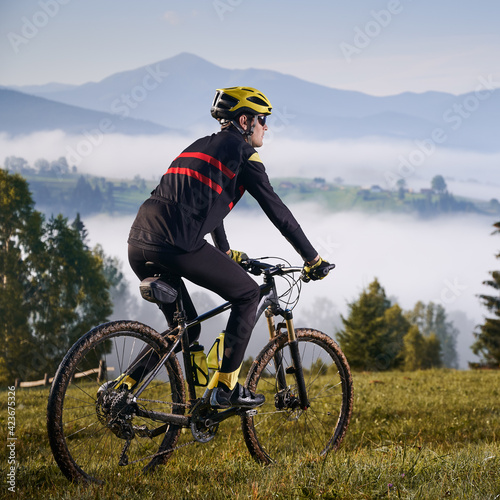 Male cyclist riding bicycle in the mountains.