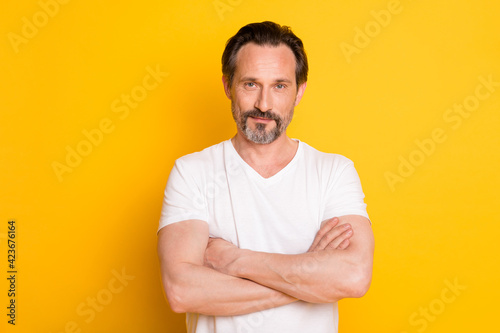 Photo of self-assured mature bearded guy crossed hands wear white t-shirt isolated yellow background