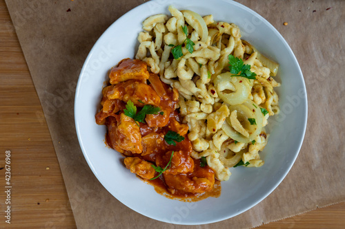 Spaetzle or Spätzle egg noodle pasta with chicken, onions and seasoning. Traditional European cuisine dish (Swabian, German, Austrian, Hungarian). Delicious gluten free Knöpfle bowl. Top view