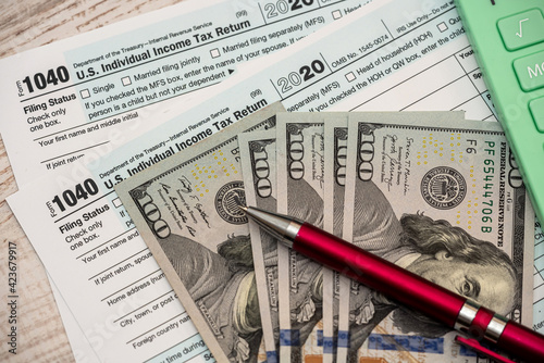1040 US tax form with pen and dollars on desk