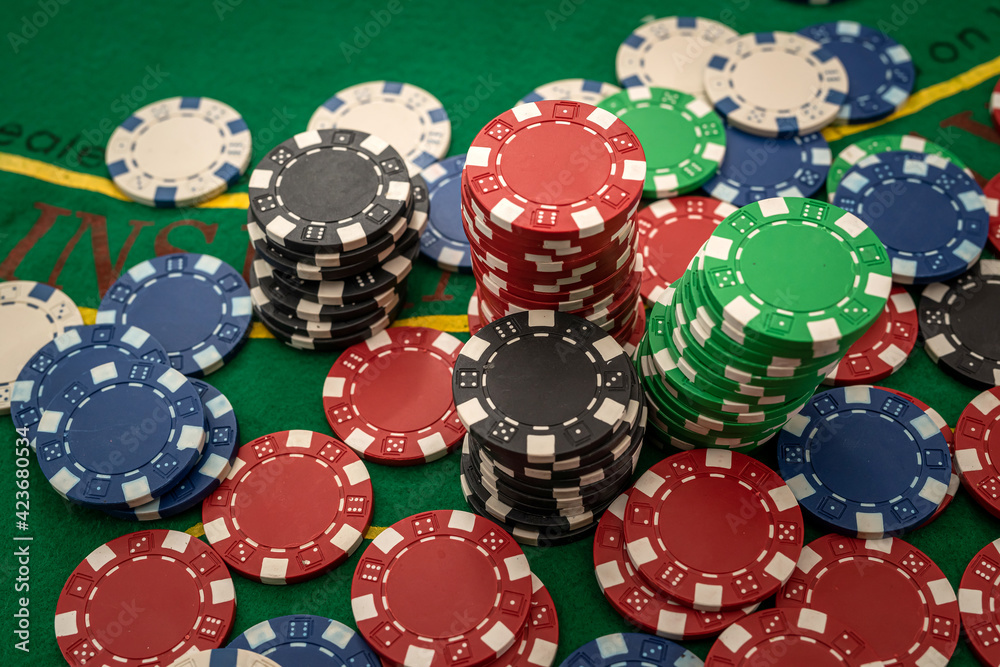 Gambling chips on green table in casino Gambling chips on green table in casino