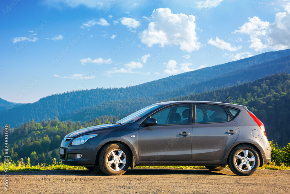 mizhhirya, ukraine - AUG 08, 2020: car on the concrete parking on top of the mountain in morning light. travel countryside concept. beautiful nature scenery views in summer with clouds on the blue sky - obrazy, fototapety, plakaty 