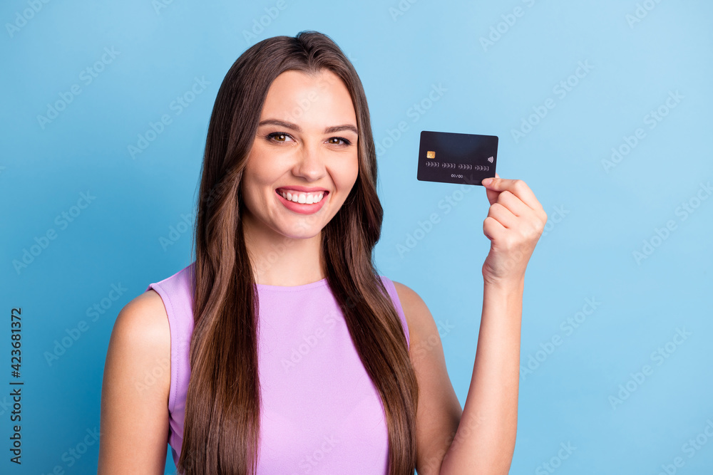Photo portrait of happy cheerful girl demonstrating bank card smiling isolated on bright blue color background Photo portrait of happy cheerful girl demonstrating bank card smiling isolated on bright blue color background