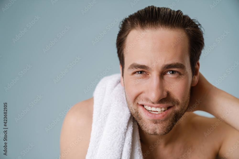 Obraz premium Shirtless white man smiling at camera while posing with towel
