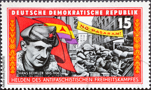 Leinwand Poster a postage stamp from Germany, GDR showing a portrait of Hans Beimler, street fight in Madrid under the slogan No Pasaran