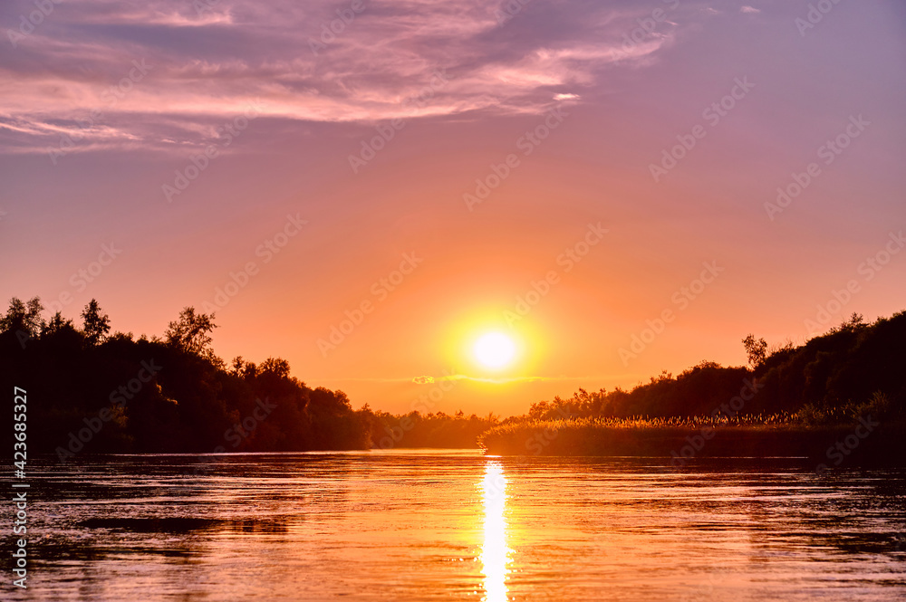 Magic atmosphere of a romantic evening; golden sunset on the river