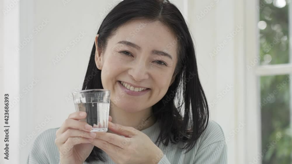 水の入ったコップを持つ笑顔の女性 水の入ったコップを持つ笑顔の女性