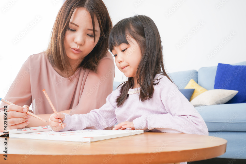 お母さんと一緒にお勉強をする小さな女の子 お母さんと一緒にお勉強をする小さな女の子