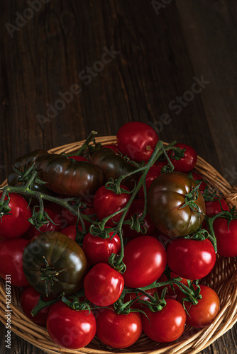 Various kind of tomatoes in the basket.Rustic food fhotography.Top view with copy space. photo