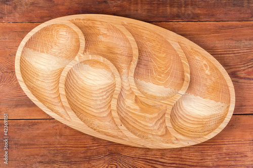 Empty wooden compartmental dish on a rustic table, top view photo