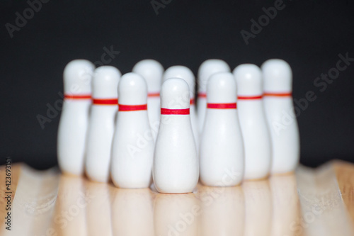 Bowling. Ten pins in white on a bowling lane. Black background. Copy space. Space for text