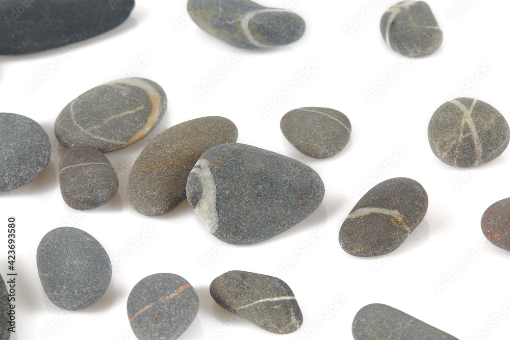 Grey pebbles isolated on white background. Grey sea stones with white stripes isolated on white. Studio shot. Grey pebbles isolated on white background. Grey sea stones with white stripes isolated on white. Studio shot.