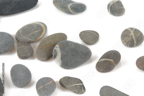 Grey pebbles isolated on white background. Grey sea stones with white stripes isolated on white. Studio shot.