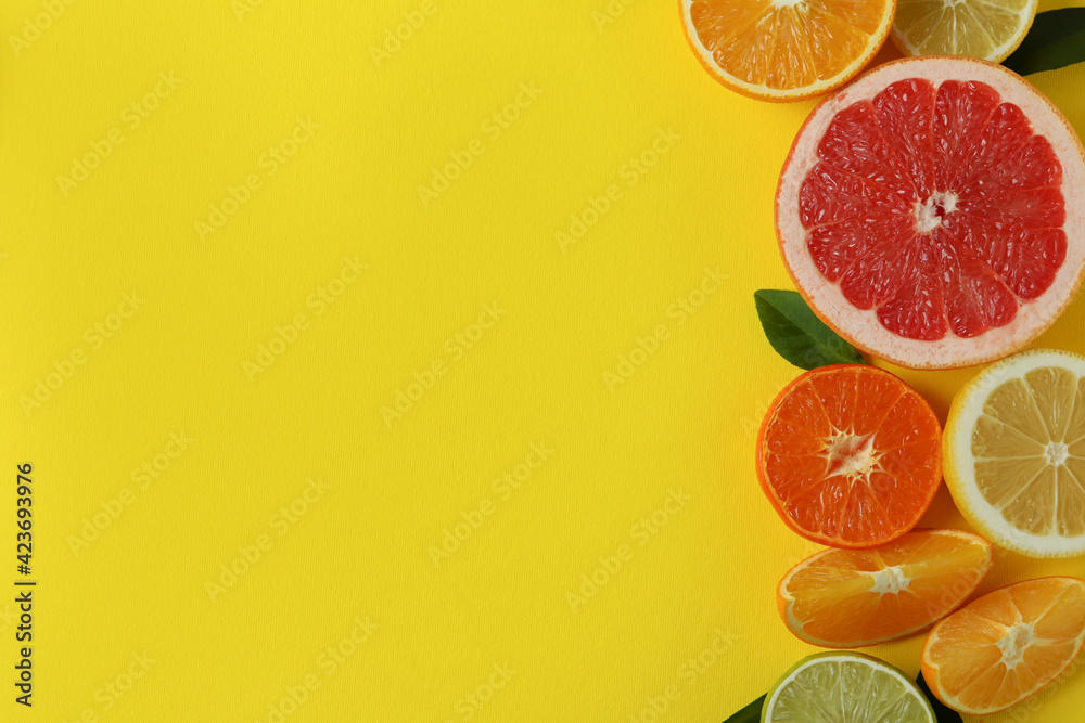 Ripe citrus on yellow background, space for text