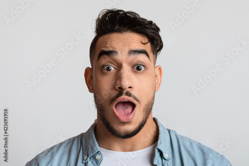 Closeup portrait of shocked young arab man looking at camera with astonishment